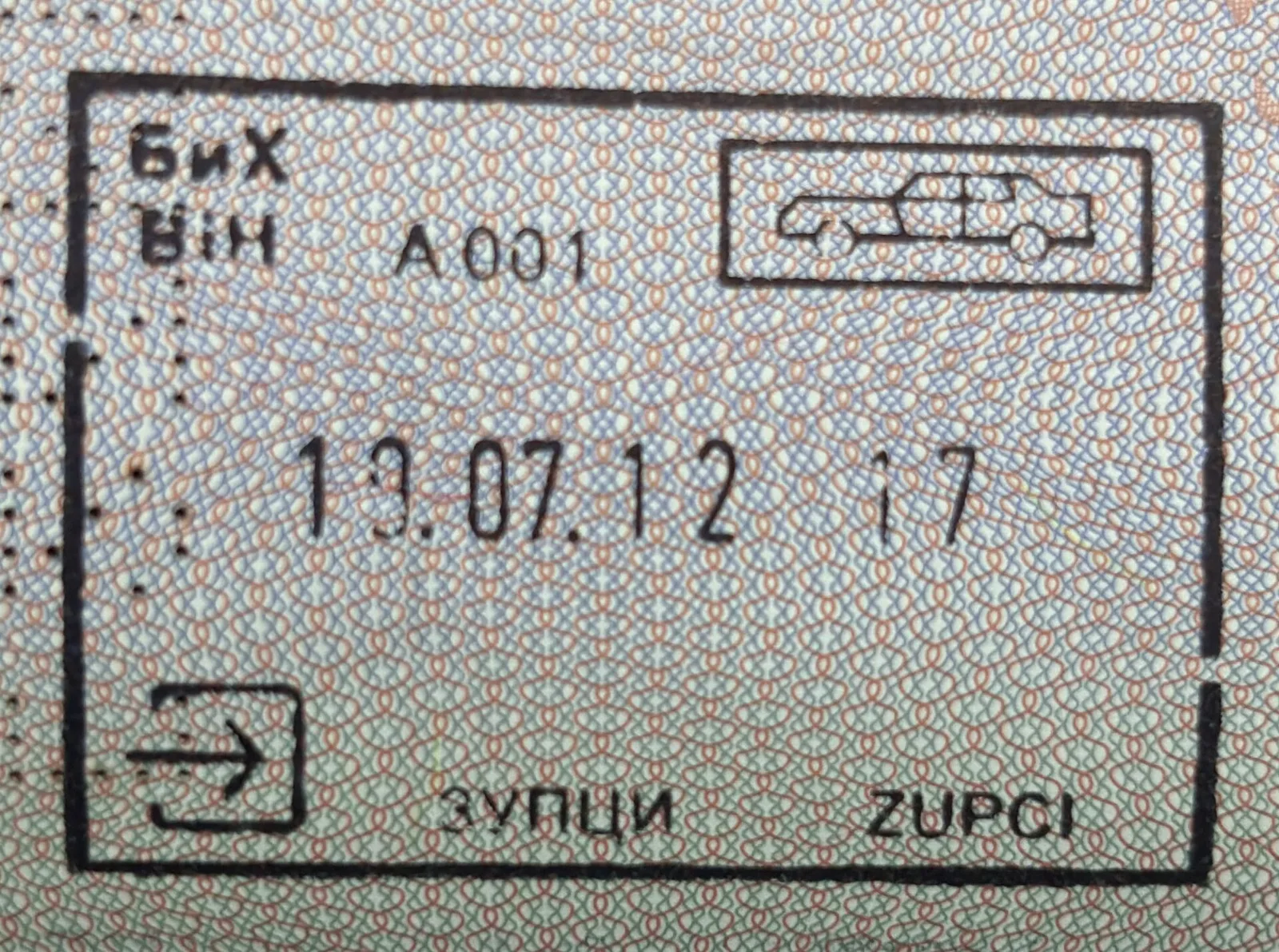 חותמת ויזה במדבקה בתוך דרכון לצד עט וטופס כניסה לאינדונזיה
